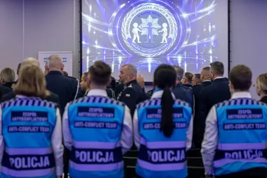 Funkcjonariusze policji w kamizelkach zespołów antykonfliktowych stoją podczas uroczystości prezentującej logo Grupy Antykonfliktowej Komendy Wojewódzkiej Polic